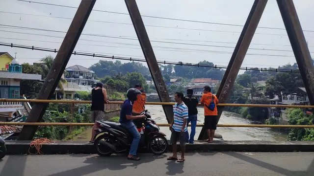 Warga dan petugas dari BPBD Kota Bogor memantau kemunculan buaya di Sungai Cisadane dari atas Jembatan Pamoyanan. (Liputan6.com/Achmad Sudarno)