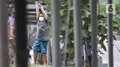 Seorang anak berolahraga di sekitar taman Rumah Sakit Darurat (RSD) Wisma Atlet, Kemayoran, Jakarta, Minggu (6/12/2020). Setiap pagi dan sore hari pihak RSD Wisma Atlet memperbolehkan pasien Covid-19 keluar kamar untuk berolahraga sekaligus menikmati udara segar. (merdeka.com/Iqbal Nugroho)