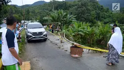 Kendaraan melintas dekat lokasi jalan longsor di Desa Bondawuna, Kabupaten Bone Bolango, Gorontalo, Selasa (30/4/2019). Hujan yang mengguyur wilayah Kabupaten Bone Bolango mengakibatkan empat desa di Kecamatan Suwawa Selatan, dan Bulango Timur Bone Bolango banjir. (Liputan6.com/Arfandi Ibrahim)