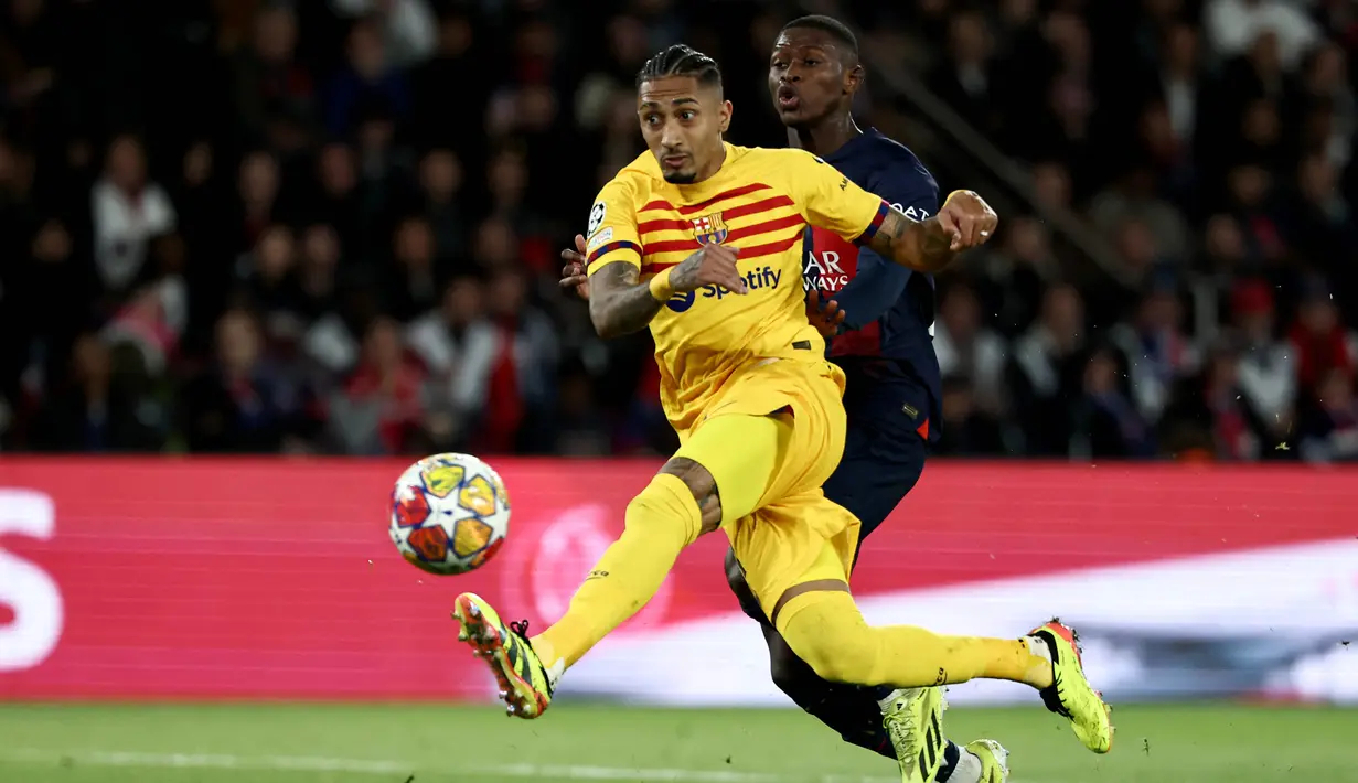 Pemain Barcelona, Raphinha, melepaskan tendangan saat melawan Paris Saint-Germain pada laga leg pertama perempat final Liga Champions di Stadion Parc des Princes, Kamis (11/4/2024). Rapinha memborong dua dari tiga gol kemenangan Barca. (AFP/Franck Fife)
