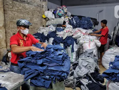 Relawan merapikan karung yang berisi pakaian bekas tidak layak pakai di Jakarta, Kamis (17/4/2025). (Liputan6.com/Angga Yuniar)