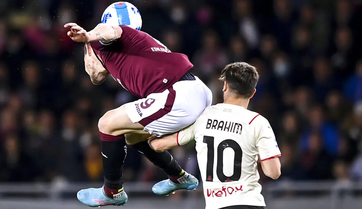 Pemain Torino Andrea Belotti (kiri) berebut bola dengan pemain AC Milan Brahim Diaz pada pertandingan sepak bola Serie A di Olimpico Grande Torino Stadium, Turin, Italia, 10 April 2022. Pertandingan berakhir tanpa gol. (Fabio Ferrari/LaPresse via AP)