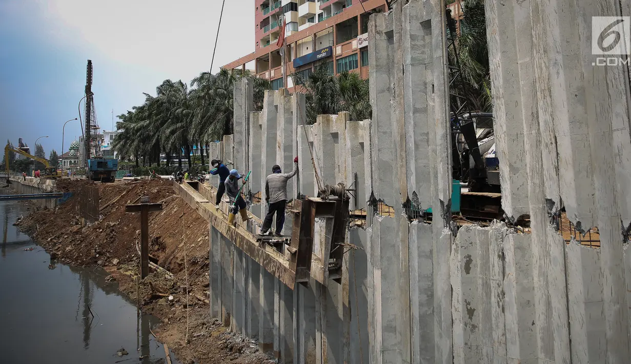 Sejumlah pekerja menyelesaikan pembangunan turap Kali Sunter Jakarta Utara, Selasa (18/12). Pembangunan turap ini merupakan bagian dari proyek normalisasi kali untuk mengantisipasi banjir di musim penghujan. (Liputan6.com/Fery Pradolo)