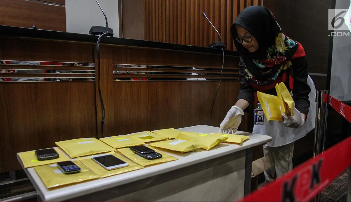Petugas menata barang yang akan dilelang usai pemberian keterangan di Gedung KPK, Jakarta, Selasa (21/11). Sebanyak 58 obyek barang hasil rampasan koruptor akan dilelang di Gedung KPK lama pada 24 November mendatang. (Liputan6.com/Faizal Fanani)