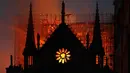 Api dan asap mengepul dari kebakaran Gereja Katedral Notre-Dame di pusat kota Paris, Prancis, pada Senin (15/4) waktu setempat. Api dengan cepat melalap bagian atap gereja yang dibangun pada abad ke-12 itu dan merupakan salah satu ikon wisata di Paris. (AP Photo/Thibault Camus)
