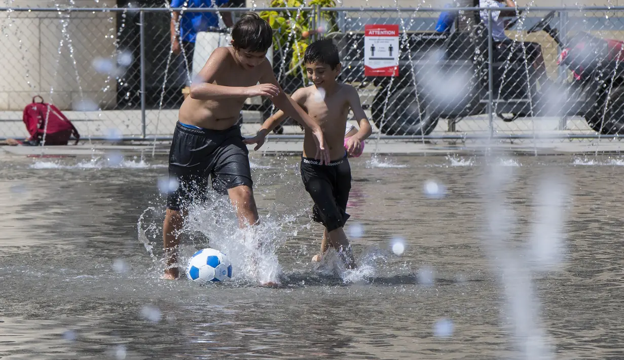 Anak-anak bermain di kolam dangkal di Toronto, Kanada (23/8/2020). Departemen Lingkungan dan Perubahan Iklim Kanada mengeluarkan peringatan cuaca panas untuk Toronto dengan suhu yang diperkirakan akan melonjak dengan suhu terendah mencapai 30-an pada Senin (24/8). (Xinhua/Zou Zheng)