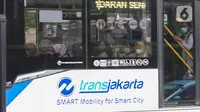 Penumpang menaiki bus Transjakarta di kawasan Jalan Mh Thamrin, Jakarta, Rabu (25/5/2022). Kawasan Jabodetabek memberlakukan PPKM Level 1 mulai 24 Mei selama dua pekan mendatang. Selama kebijakan berlaku, karyawan di perusahaan sektor non esensial diperbolehkan bekerja dari kantor atau work from office (WFO) dengan kapasitas 100 persen. (Liputan6.com/Herman Zakharia)