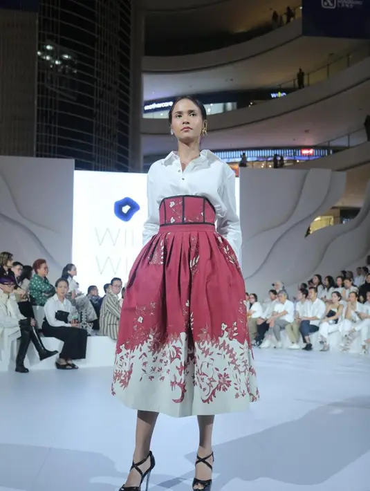 Seperti potret ini, penampilan formal dan elegan terpancar ketika rok batik high waist dipadukan dengan kemeja putih. [Dok/Fimela/Bambang E. Ros]