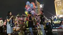 Pedagang menjual terompet dan balon pada malam pergantian tahun di kawasan Bundaran HI, Jakarta, Senin (31/12). Pergantian tahun dimanfaatkan pedagang untuk mencari keuntungan dengan berjualan pernak pernik tahun baru.(Liputan6.com/Angga Yuniar)