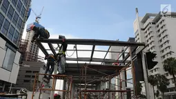Pekerja menyelesaikan proyek pembangunan Halte Transjakarta Bundaran HI di Jakarta, Sabtu (9/3). Halte ini menjadi salah satu simpul penting dalam Jak Lingko atau program transportasi satu harga. (Liputan6.com/Herman Zakharia)