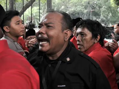 Kader PDIP Adian Napitupulu saling dorong dengan petugas saat hendak masuk ke Gedung KPU, Jakarta, Selasa (17/7). Elite serta massa PDIP terlibat kericuhan saat hendak mengantarkan pengurus DPP mendaftarkan bakal caleg. (Merdeka.com/ Iqbal S. Nugroho)