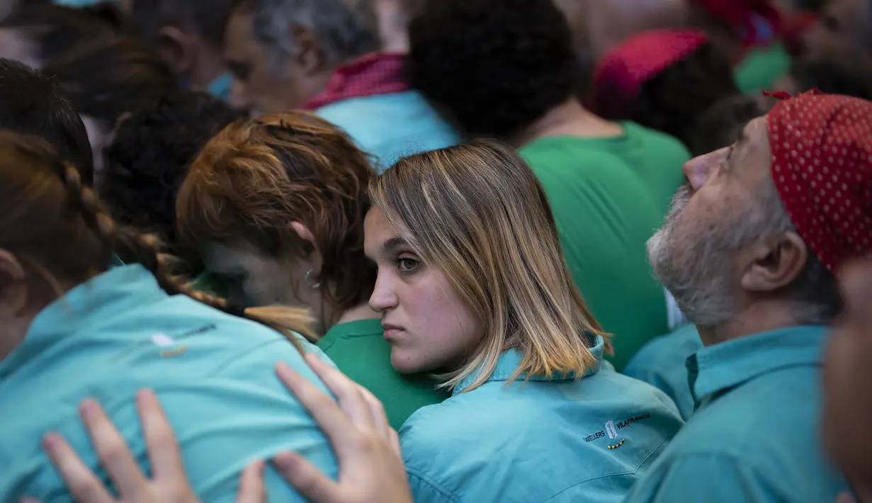 Seorang anggota "Castellers de Vilafranca" membantu timnya membentuk menara manusia selama Kompetisi Menara Manusia ke-28 di Tarragona, Spanyol, Minggu (2/10/2022). Setiap kelompok terdiri atas puluhan hingga ratusan orang, mulai dari kaum pria, wanita, orang tua, hingga anak-anak ikut dalam perlombaan ini. (AP Photo/Joan Mateu Parra)