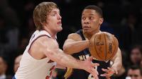 Pemain Pelicans, Tim Frazier (kanan) mengumpan bola melewati hadangan pemain New York Knicks, Ron Baker (kiri) pada laga NBA basketball game di Madison Square Garden, New York (9/1/2017). Pelicans menang 110-96.  (AP/Kathy Willens)