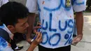 Siswa SMK Kemala Bhayangkari 1 Jakarta, meluapkan kegembiraanya dengan melakukan aksi corat-coret seragam menggunakan cat warna setelah mengikuti Ujian Nasional (UN), Kamis (16/4/2015). (Liputan6.com/Herman Zakharia)