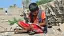 Anak-anak Yaman menghadiri kelas di luar ruangan sebuah sekolah yang rusak parah pada hari pertama tahun ajaran baru di provinsi barat Yaman yang dilanda perang Hodeida, Senin (17/10/2022). UNICEF memperkirakan bahwa lebih dari dua juta anak telah putus sekolah di Yaman, peningkatan hampir setengah juta sejak perang pecah pada 2015. (Foto oleh Khaled ZIAD / AFP).