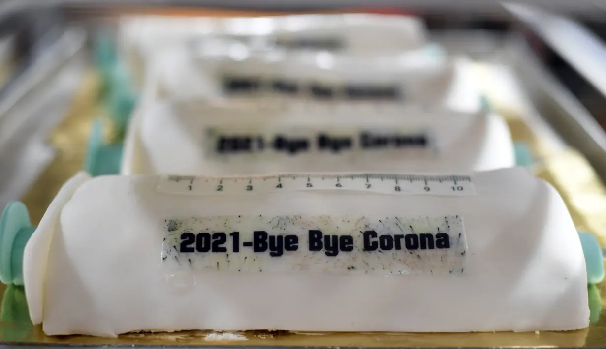 Kue berbentuk jarum suntik vaksinasi melawan virus corona dengan tulisan '2021 Selamat Tinggal COVID-19' di toko roti Schuerener Backparadies di Dortmund, Jerman, 6 Januari 2021. Saat ini sudah ada empat vaksin Covid-19 yang disetujui sejumlah negara untuk melakukan vaksinasi. (Ina FASSBENDER/AFP)