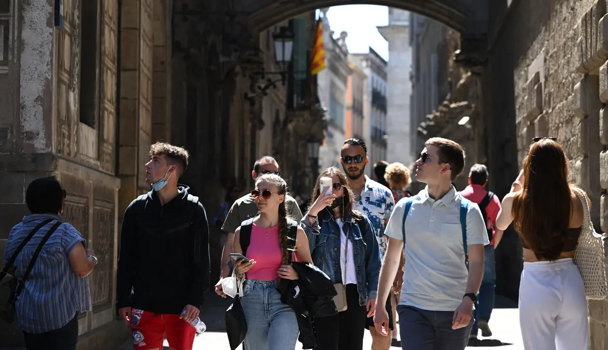 Turis berjalan di sepanjang Jalan Bisbe di Barcelona, ​​​​pada 11 Mei 2022. Pengunjung sekali lagi memadati jalan-jalan sempit di kawasan Gothic Barcelona yang sempit saat perjalanan global bangkit kembali dari pandemi COVID-19, menghidupkan kembali kekhawatiran atas pariwisata massal di kota pelabuhan Spanyol.
(LLUIS GEN / AFP)