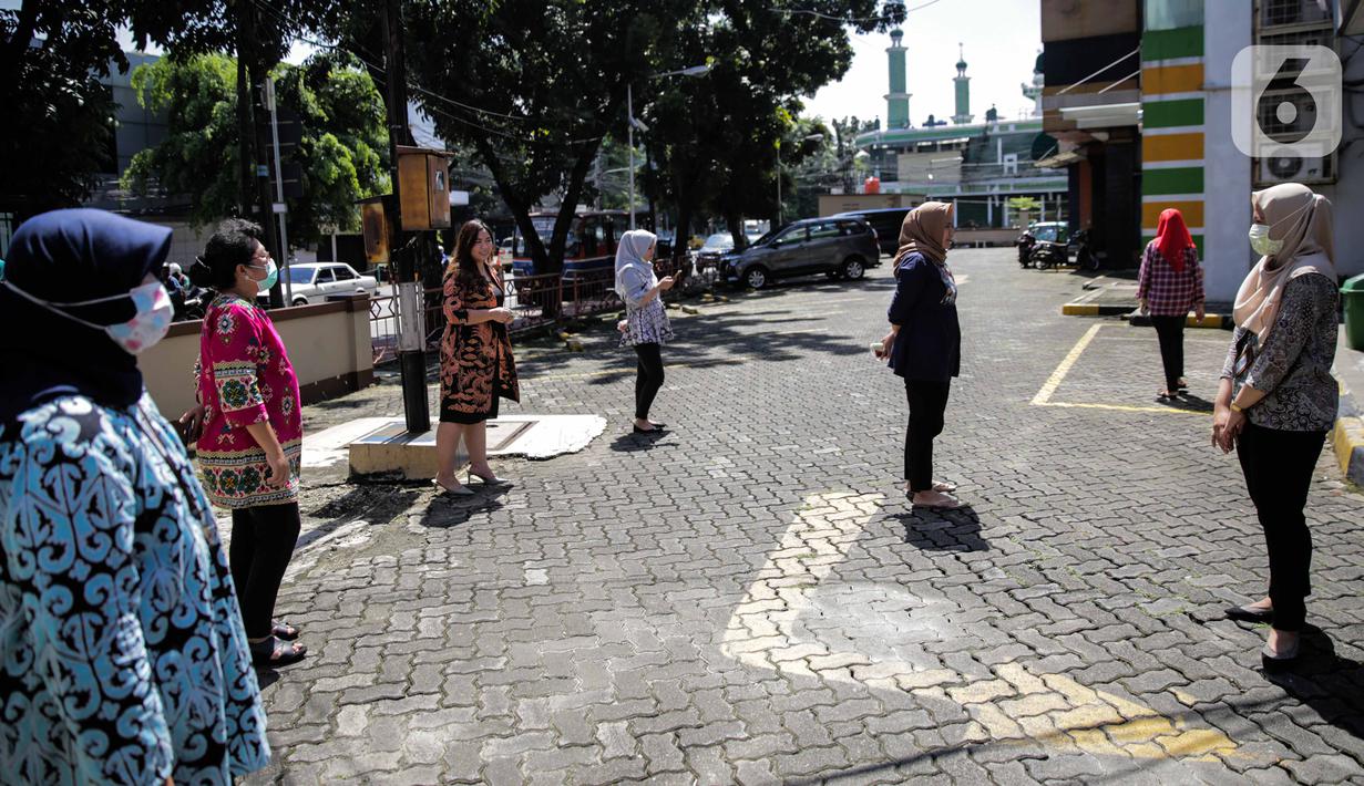 Sejumlah pegawai berjemur di bawah sinar matahari di Kawasan Fatmawati, Jakarta, Selasa (31/3/2020). Berjemur diri di bawah sinar matahari saat pagi merupakan salah satu upaya yang paling sederhana untuk menjaga kesehatan selama wabah virus COVID-19. (Liputan6.com/Faizal Fanani)