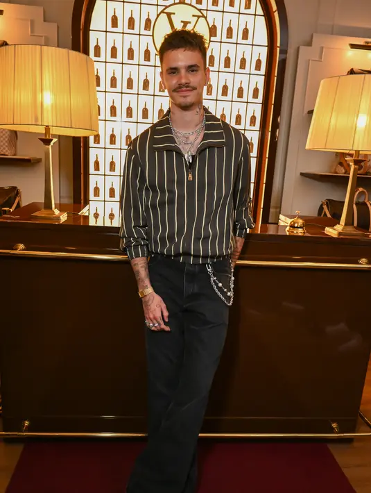 Romeo Beckham tampil effortless dengan stripe shirt dengan celana black denim dan rantai [Louis Vuitton]