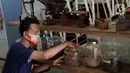 Seorang pria mengambil ramuan jamu tradisional di kafe Suwe Ora Jamu, kawasan M Bloc, Jakarta, Jumat (10/7/2020). Kafe yang menjadi tempat alternatif nongkrong sehat bagi kawula muda ini menyediakan berbagai jenis ramuan jamu tradisional. (Liputan6.com/Herman Zakharia)