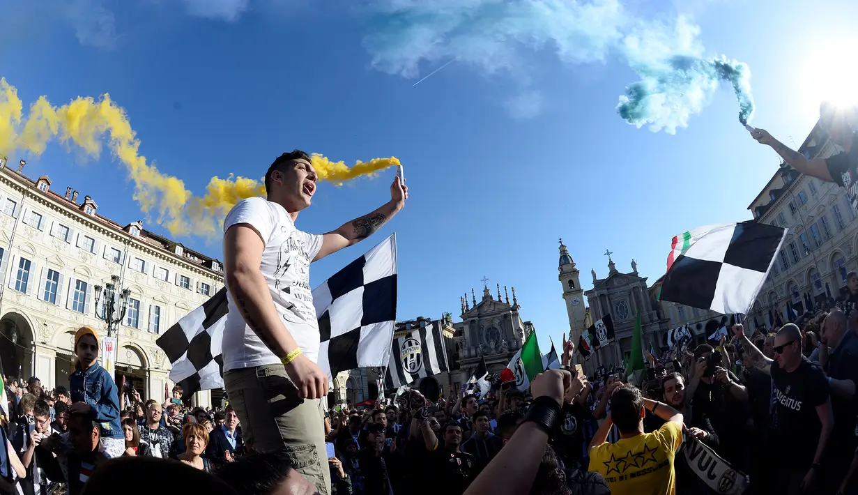 Senangnya ribuan suporter Juventus merayakan kemenangan usai merebut gelar Serie A Italia di pusat kota Turin, Italia (25/4). Juventus berhak meraih gelar Scudetto mereka yang ke-34. (REUTERS/Giorgio Perottino)