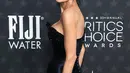 Tampilannya makin sensasional dengan rambut hitam disisir ke belakang dan sanggul balerina yang ramping [@criticschoice]