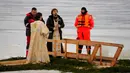 Para pendeta Ortodoks Rusia melakukan kebaktian Epiphany di sebuah lubang es di Kronstadt, luar St. Petersburg, Rusia, 18 Januari 2023. Ribuan pengikut Gereja Ortodoks Rusia terjun ke sungai dan kolam es di seluruh negeri untuk menandai Epiphany, membersihkan diri dengan air yang dianggap suci untuk hari itu. (AP Photo/Dmitri Lovetsky)