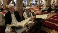 Sejumlah pria membaca Al-Quran selama bulan Ramadan di Masjid Agung Sanaa, Yaman, Minggu (26/4/2020). Kaligrafi dan dekorasi merupakan kekhasan Masjid Agung Sanaa. (Mohammed HUWAIS/AFP)