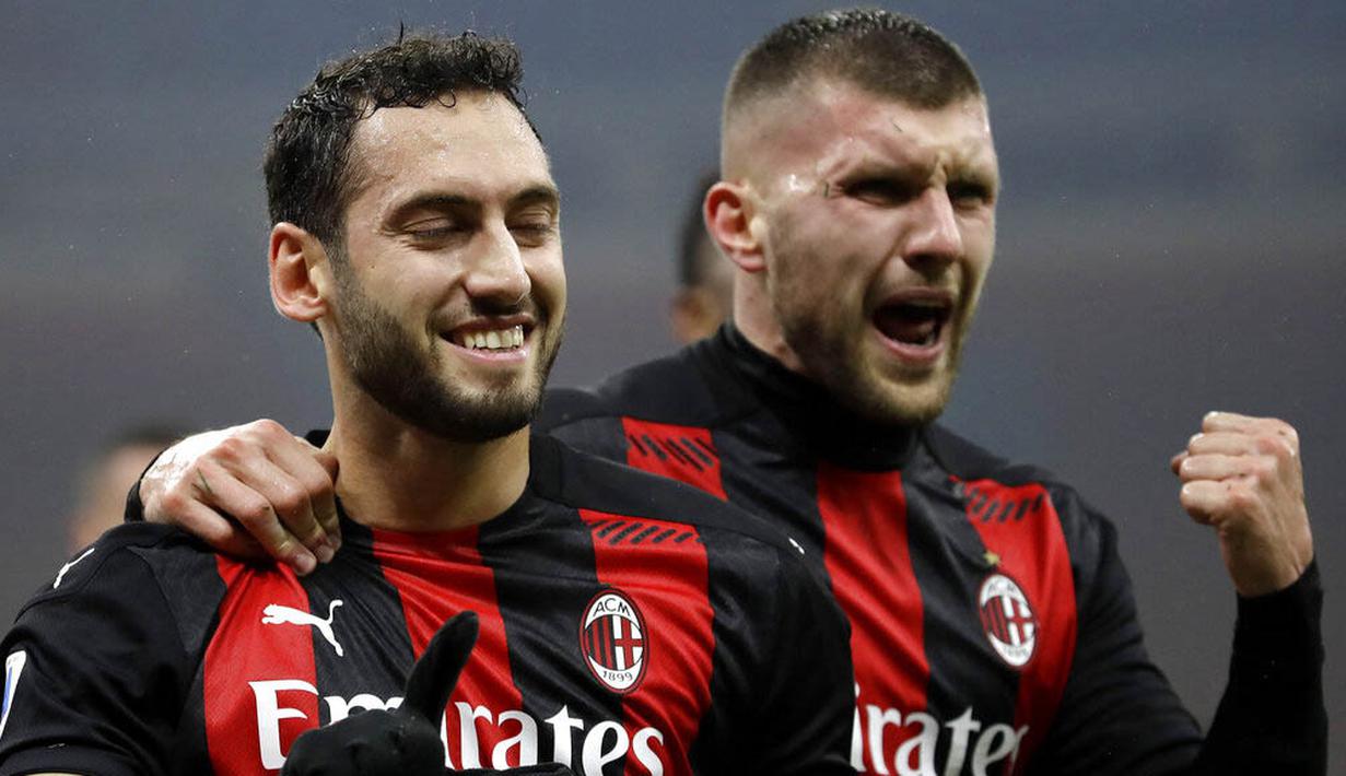 Pemain AC Milan, Hakan Calhanoglu dan Ante Rebic, melakukan selebrasi usai mencetak gol ke gawang Lazio pada laga Liga Italia di Stadion San Siro, Rabu (23/12/2020). AC Milan menang dengan skor 3-2. (AP/Luca Bruno)