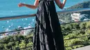 Luna Maya tampil mengenakan dress panjang hitam ruffle yang dipadukan sandal bertali. Dipadukan kalung chokernya. Credit: Havaianas