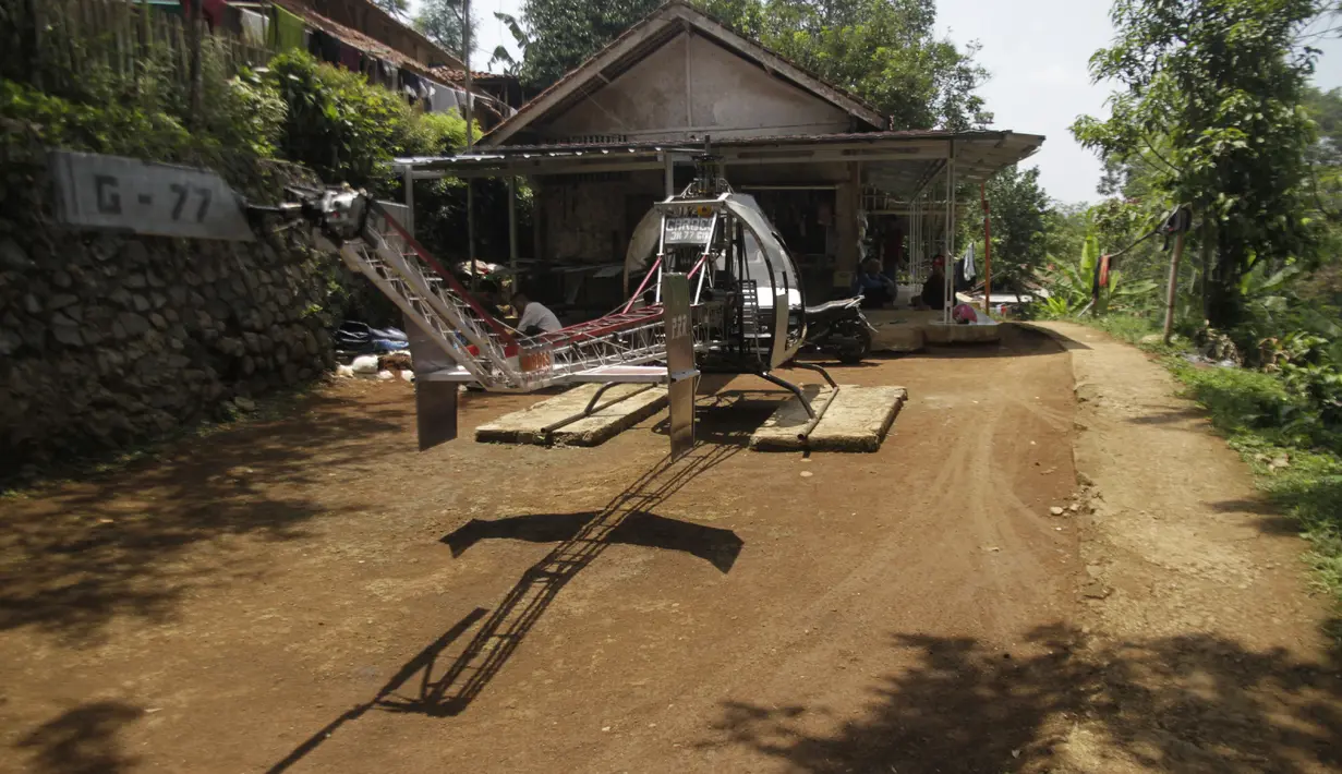 Gambar yang diambil pada 17 November 2019, Jujun Junaedi duduk di dekat helikopter buatannya di halaman belakang rumahnya di Sukabumi. Jujun yang berusia 41 tahun ini menargetkan helikopter berbahan bakar bensinnya rakitannya dapat diuji terbang pada akhir 2019. (Wulung WIDARBA/AFP)