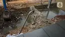 Alat berat mengeruk beton turap saluran air yang longsor di kawasan Jagakarsa, Jakarta, Kamis (17/9/2020). Selain karena hujan lebat, longsor diduga karena erosi tanah akibat pembuangan saluran air pencuci piring dan toilet dari warung makan di sekitar bantaran. (Liputan6.com/Immanuel Antonius)