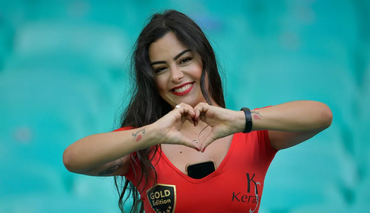 Model Larissa Riquelme berpose dengan memberi isyarat hati sebelum pertandingan Copa America 2019 antara Paraguay dengan Kolombia di Fonte Nova Arena, Salvador, Brasil, Minggu (23/6/2019). Wanita cantik dan seksi ini merupakan model terbaik dan termahal di Paraguay. (Raul ARBOLEDA/AFP)