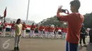 Warga berfoto di depan salah satu Pasukan Pengaman Presiden di depan Istana Negara, Miggu (17/7). Prosesi pergantian pasukan penjaga Istana Negara ini akan dijadikan objek atraksi wisata baru bagi masyarakat. (Liputan6.com/Gempur M Surya)