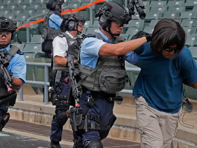 Petugas polisi menolong korban saat latihan anti-teror di Hong Kong, Jumat, (25/8). Simulasi serangan anti-teror ini untuk persiapan sebuah konser penyanyi Ariana Grande pada 21 September 2017. (AP Photo / Vincent Yu)