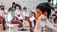 Petugas kesehatan menyiapkan vaksin COVID-19 saat akan menyuntik seorang murid di SDN Cempaka Putih Timur 03 Pagi, Jakarta, Selasa (14/12/2021). Pemerintah mulai melakukan vaksinasi COVID-19 kepada anak usia 6-11 tahun. (merdeka.com/Iqbal S. Nugroho)