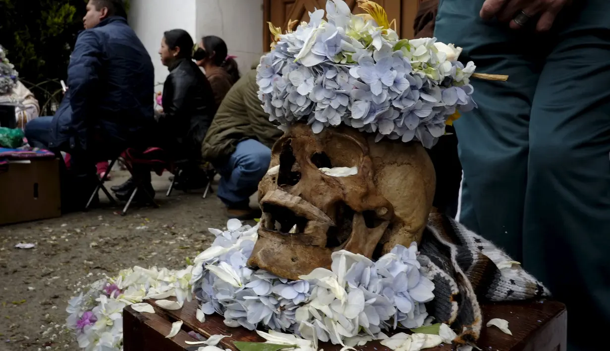 Tengkorak dihias dengan bunga  selama upacara Dia de las natitas atau hari tengkorak di pemakaman Umum La Paz, Bolivia, (8/11/2015).  Tiap tahun mereka berkumpul di pemakamaan untuk melakukan ritual mendoakan leluhur  mereka. (REUTERS/David Mercado)