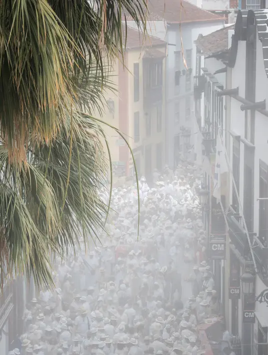 Orang-orang yang berselimut bedak ambil bagian dalam karnaval jalanan 'Los Indianos' di Santa Cruz de la Palma, Spanyol, Senin (4/3). 'Los Indianos' atau dikenal dengan festival kaum Indian dan sekarang dikenal dengan pesta putih. (DESIREE MARTIN/AFP)