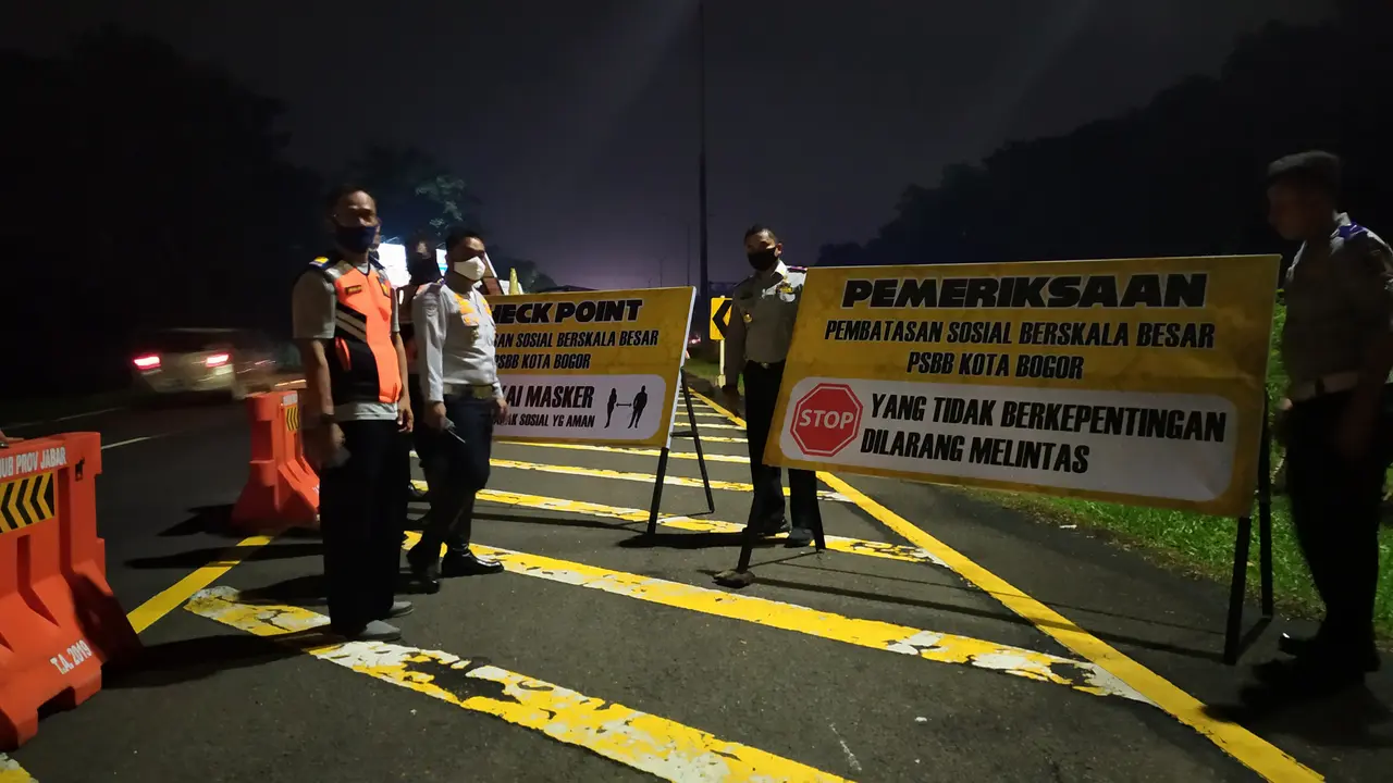 Petugas Dinas Perhubungan Kota Bogor sedang memasang pelang di check point di keluar Tol Jagorawi yang menjadi pintu masuk menuju Kota Bogor. (Liputan6.com/ Achmad Sudarno)