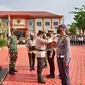 Kapolres Paser, AKBP Kade Budiyarta menyematkan pita kepada personel tanda dimulainya Operasi Patuh Mahakam 2022, halaman Mapolres Paser, Senin (13/6/2022). (Liputan6.com/istimewa)