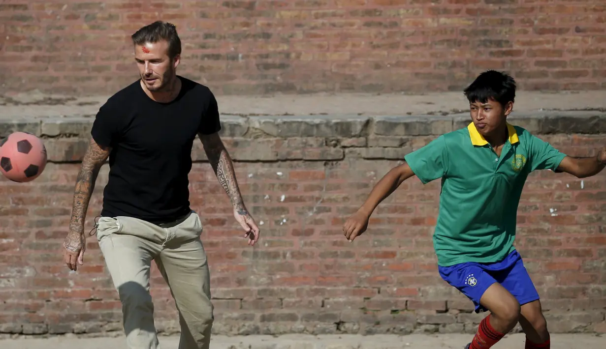 Aksi David Beckham bermain bola ketika melakukan pertandingan amal untuk mengumpulkan dana bagi UNICEF di kota tua Bhaktapur, Nepal, Jumat (6/11). (REUTERS / Navesh Chitrakar)