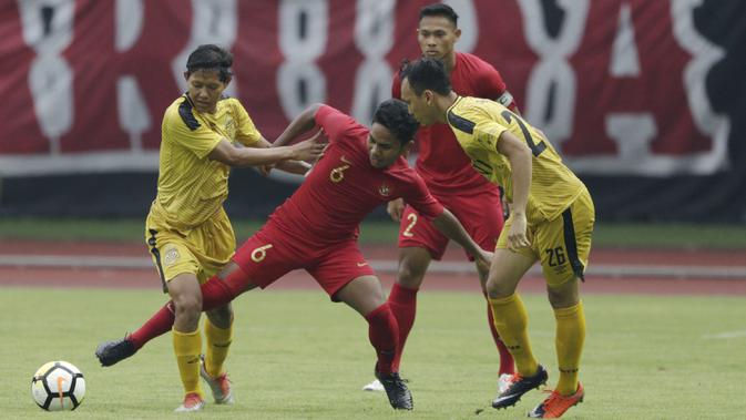 Gelandang Timnas Indonesia U-22, Rafi Syaharil, berebut bola dengan gelandang Bhayangkara FC, Adam Alis, pada laga uji coba di Stadion Patriot, Bekasi, Rabu (6/2). Keduanya bermain imbang 2-2. (Bola.com/Yoppy Renato)