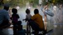 <p>Orang-orang mendinginkan diri dengan air dari pancuran saat suhu udara melebihi 42 derajat celsius di lingkar jalan di Nantes, Senin (18/7/2022). Peramal cuaca menempatkan 15 departemen di sebagian besar sisi barat Prancis ke status siaga tertinggi untuk suhu ekstrem saat gelombang panas melanda negara itu dan akan mencapai puncaknya. (Loic VENANCE / AFP)</p>