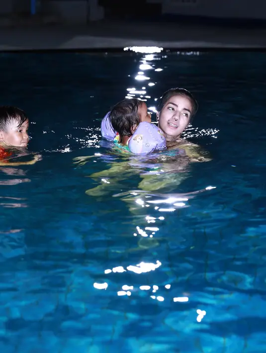 Ia juga terus memperhatikan ketiga buah hatinya yang sedang asyik bermain air. (Galih W. Satria/Bintang.com)