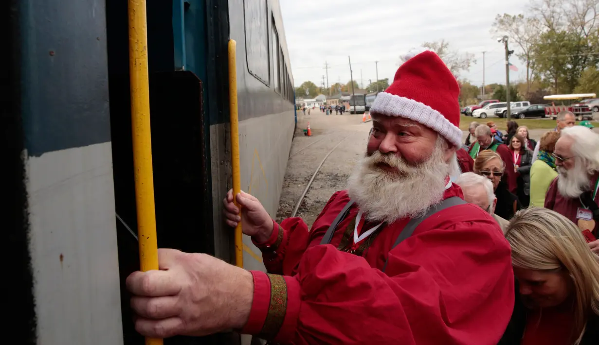Calon Santa Claus menaiki kereta uap selama pelatihan di sekolah Santa Claus Charles W. Howard di Midland, Michigan, Jumat (19/10). Para siswa datang ke sekolah itu untuk mengikuti pelatihan menjadi Sinterklas selama tiga hari. (JEFF KOWALSKY / AFP)