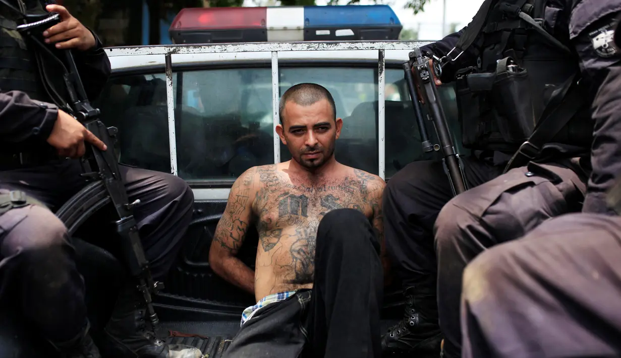 Pemimpin geng Gustavo de Jesus Vasquez Nerio alias "El Tigre" saat berada dimobil polisi setelah penangkapannya di Colon, El Salvador 30 Mei 2016. (REUTERS/Jose Cabezas)