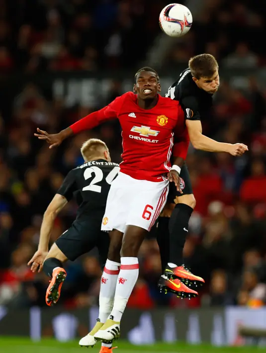 Gelandang Manchester United, Paul Pogba berebut bola udara dengan bek Zorya Luhansk, Eduard Sobol pada laga Liga Eropa di Manchester, Inggris, (29/9). MU menang atas Zorya Luhansk dengan skor 1-0. (Reuters/Jason Cairnduff)