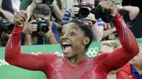 Simone Biles dari Amerika Serikat merayakan keberhasilannya meraih medali emas pada ajang artistic gymnastics Olimpiade Rio 2016 di Brasil, (14/8/2016). (AP/Dmitri Lovetsky)