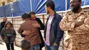 Warga menenangkan pria yang sanak keluarganya menjadi korban dalam serangan bom mobil ganda di Kota Benghazi, Libya, Rabu (24/1). Belum ada kelompok yang mengaku bertanggung jawab atas pengeboman tersebut. (AFP PHOTO/Abdullah DOMA)