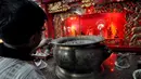 Seorang pengurus Vihara tampak membersihkan tungku dupa. Pembersihan ini dilakukan agar umat yang datang beribadah bisa menikmati kenyamanan dan khusyuk dalam berdoa, Kawasan kota Tua, Jakarta, Jumat (6/2/2015). (Liputan6.com/Faizal Fanani)